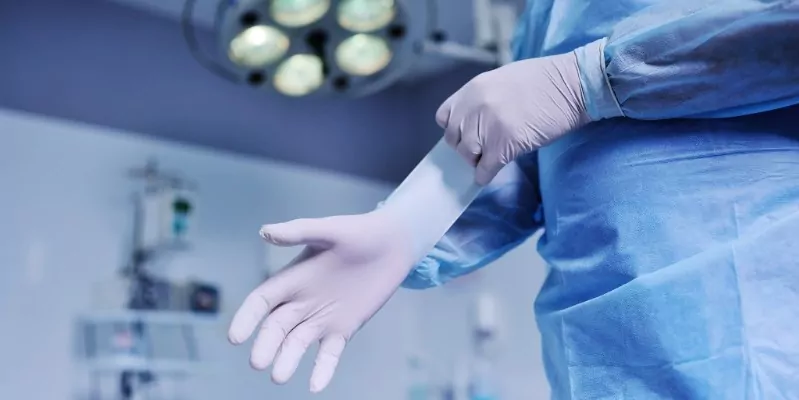 Surgeon pulling on gloves