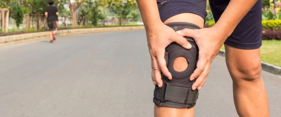 Person holding his knee in a knee brace