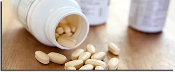 Dietary supplements spilling out of its bottle