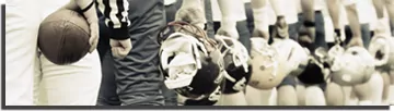 Football players with helmets off standing in a line