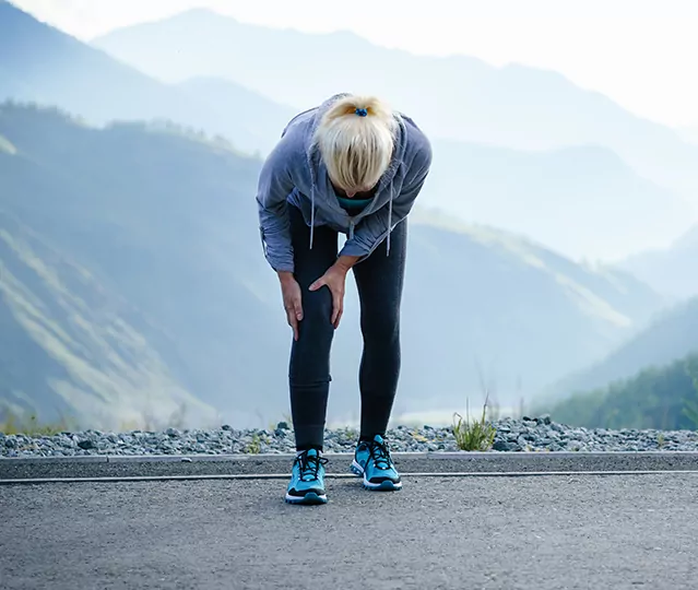 female runner holding her knee