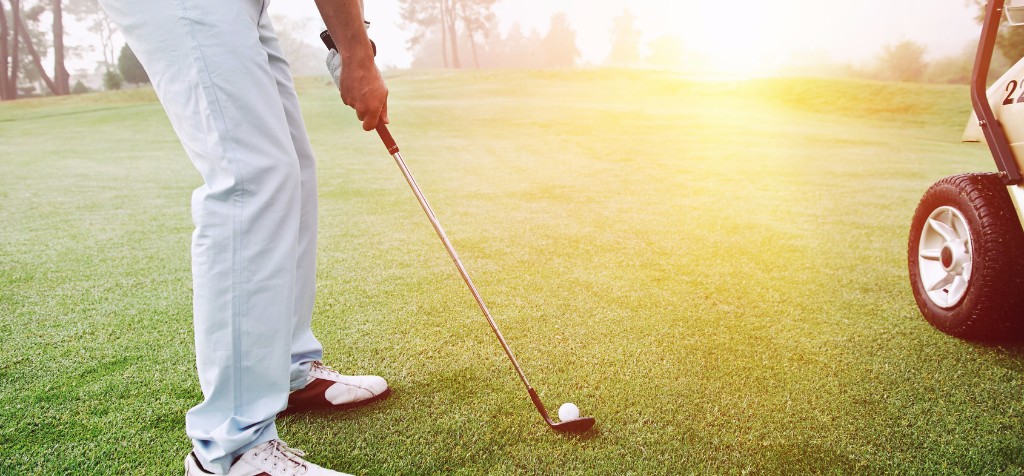 Person golfing at sunset