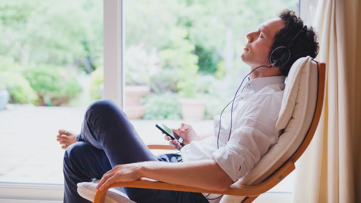 Man reclining and listening to music through headphones