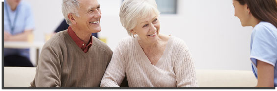 Elderly couple speaking to a nurse