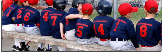 young boys in baseball uniforms sitting on the bench