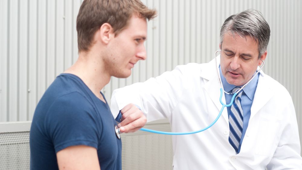 Doctor using a stethoscope to listen to a patient's chest.