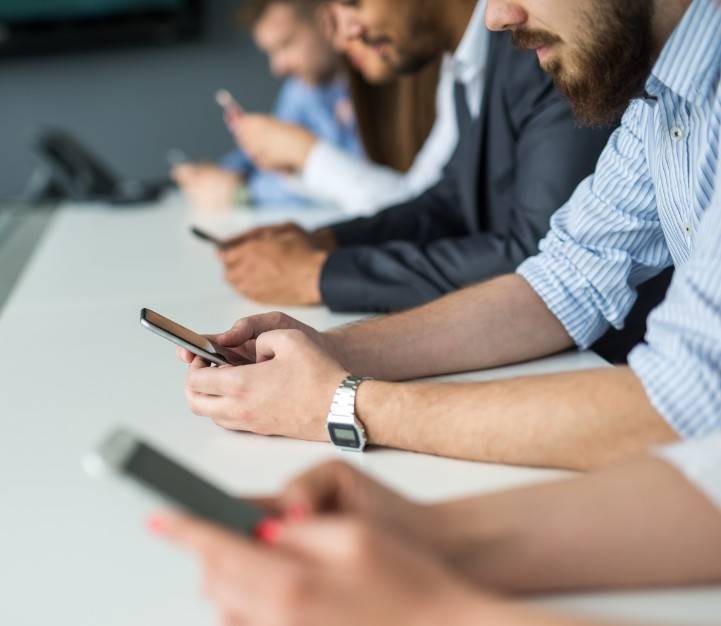 Row of people using smart phones