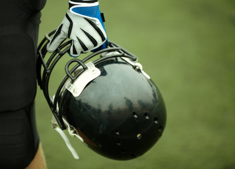 Football player holding helmet