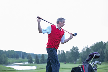 Torso Rotation Golf Stretch. Man in red sweater vest demonstrating.